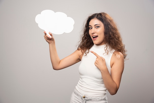 Young woman showing an empty blank white speech poster. High quality photo