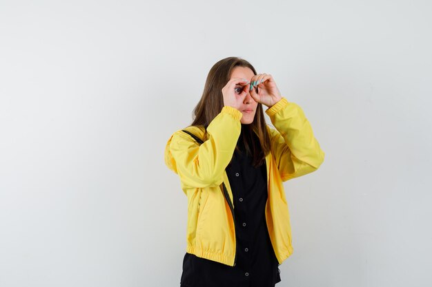 Young woman showing glasses gesture