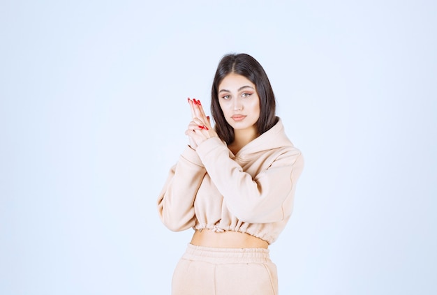 Молодая женщина, показывающая знак ручной пистолет