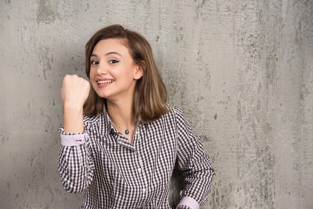 A young woman showing her fist and looking at the front 