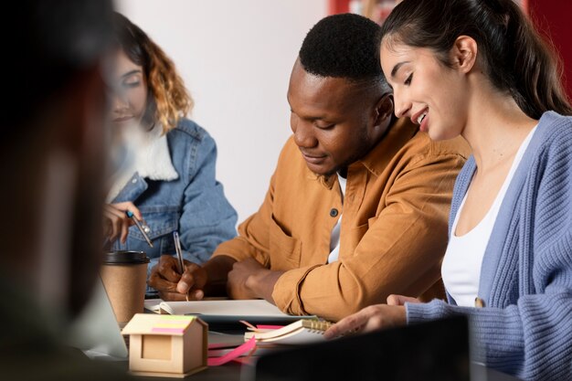 Young woman showing her friend something from a notebook