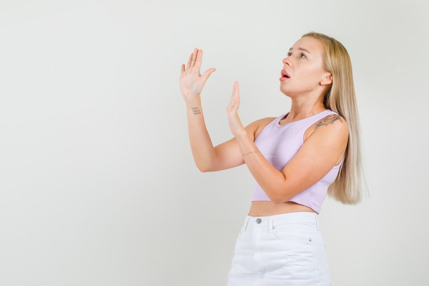 Young woman showing no gesture while looking up in singlet