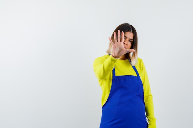 Young woman showing a number five hand sign on white background