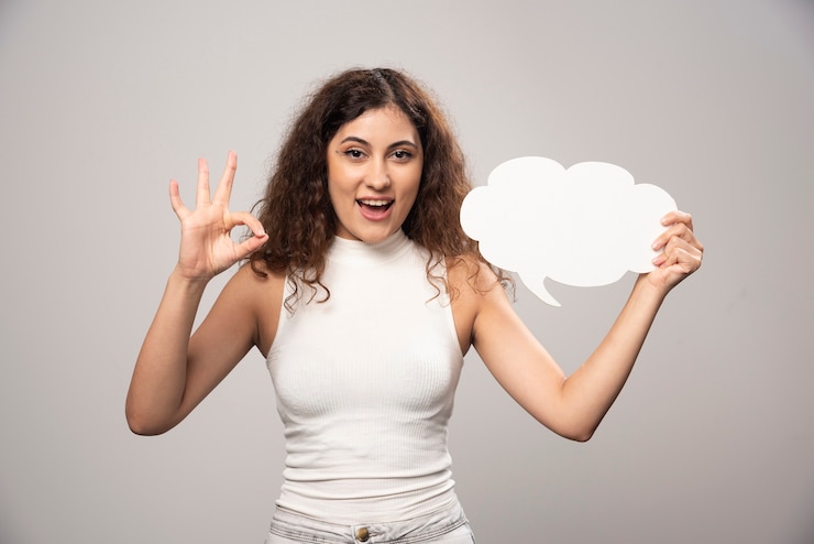 Free Photo young woman showing ok gesture and holding an blank white poster. high quality photo