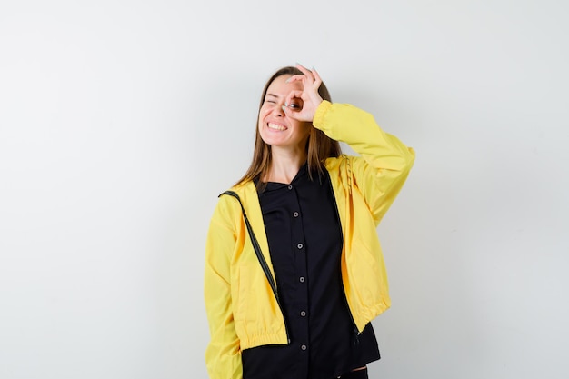 Young woman showing ok sign on eye