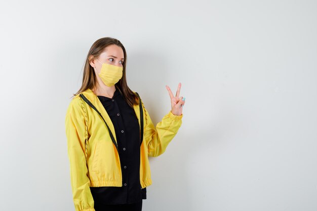 Young woman showing peace gesture