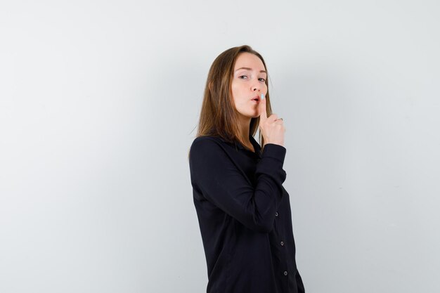 Young woman showing silence gesture