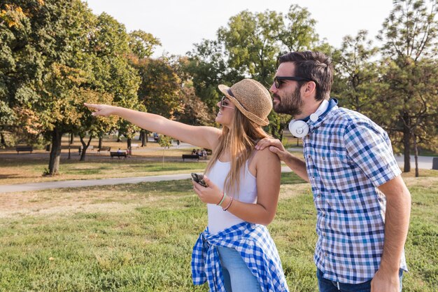 Young woman showing something to her boyfriend at outdoors