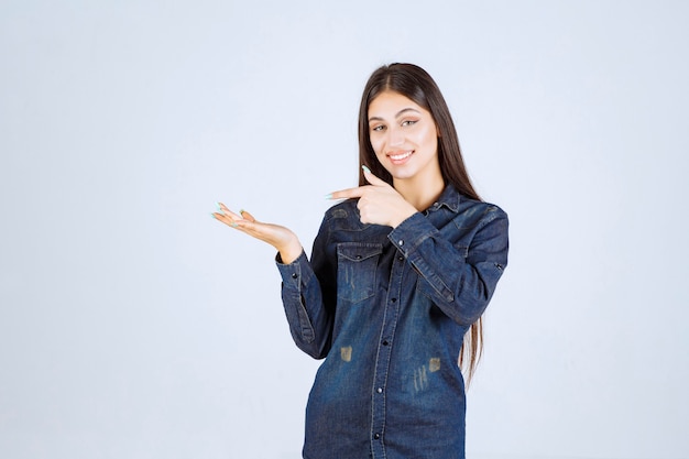 Young woman showing something in her open hand