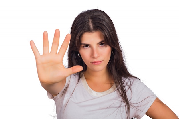 Young woman showing stop gesture with her palm.