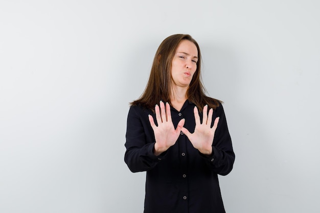 停止ジェスチャーを示す若い女性