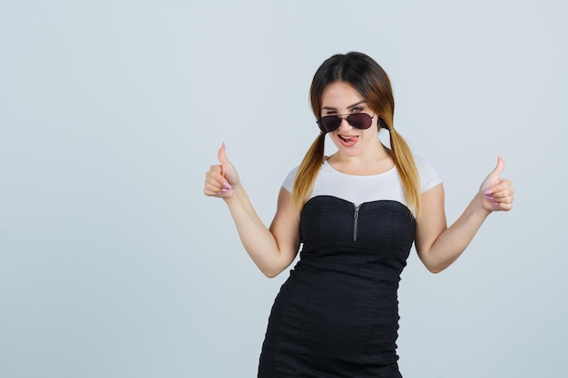 Young woman showing thumbs up while winking