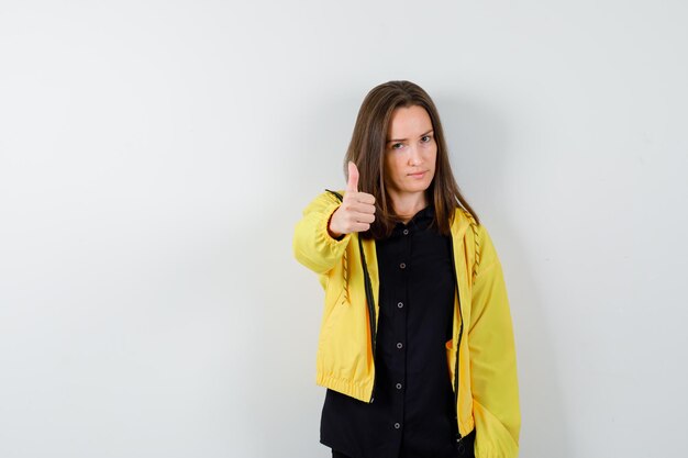 Young woman showing thumbs up