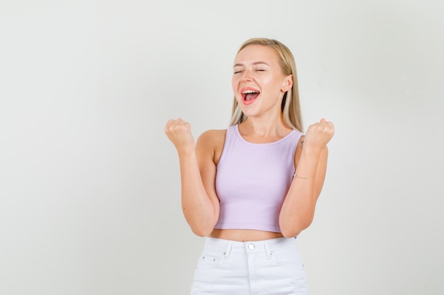 Young woman showing winner gesture in singlet