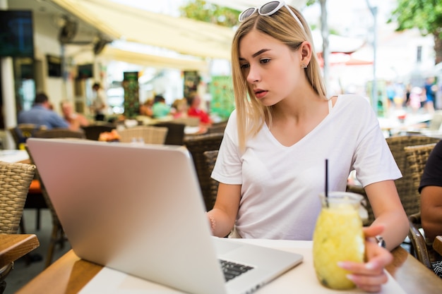 Young woman sits in front of opened laptop computer