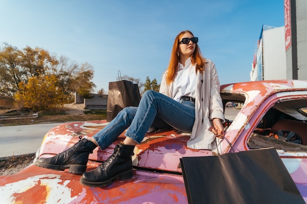 若い女性は古い装飾された車に座っています