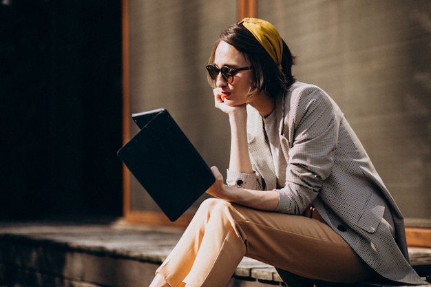 裏庭に座って本を読む若い女性