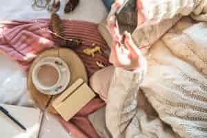 Foto gratuita giovane donna che si siede sulla coperta con una tazza di caffè