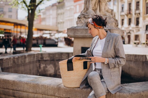 Young woman sitting by the fountain