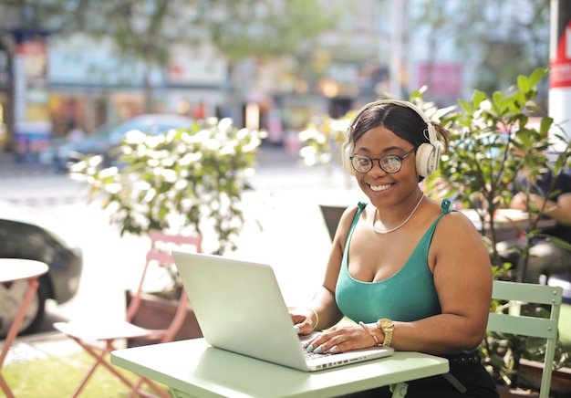 молодая женщина сидит в кафе с компьютером