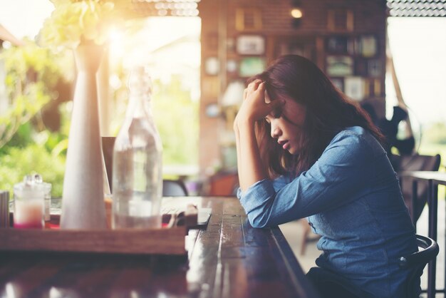 Young woman sitting in a cafe with her laptop, Stressful for wor