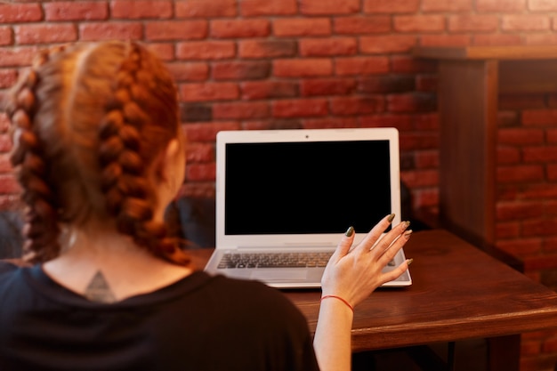 Free photo young woman sitting at cafe with laptop