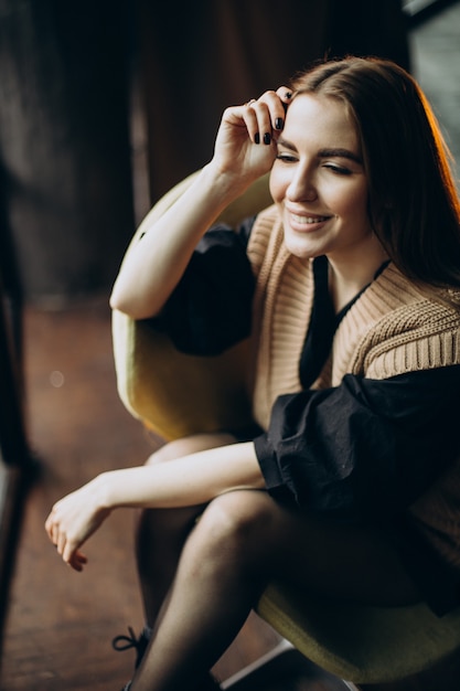 Free Photo Young woman sitting on chair alone