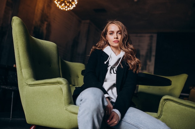 Young woman sitting in a chair inside a cafe