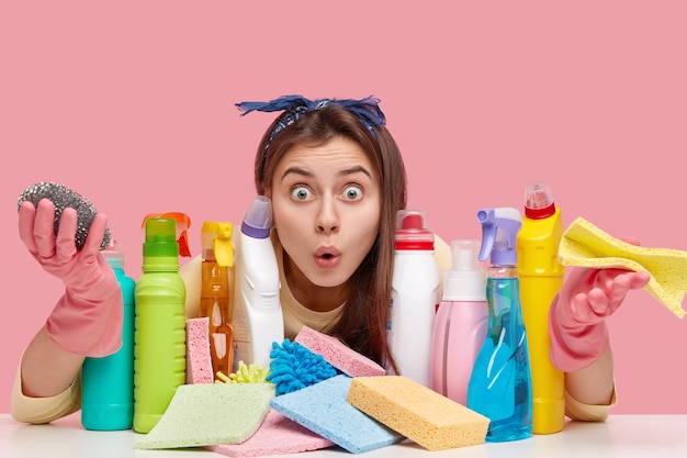 Young woman sitting next to cleaning products