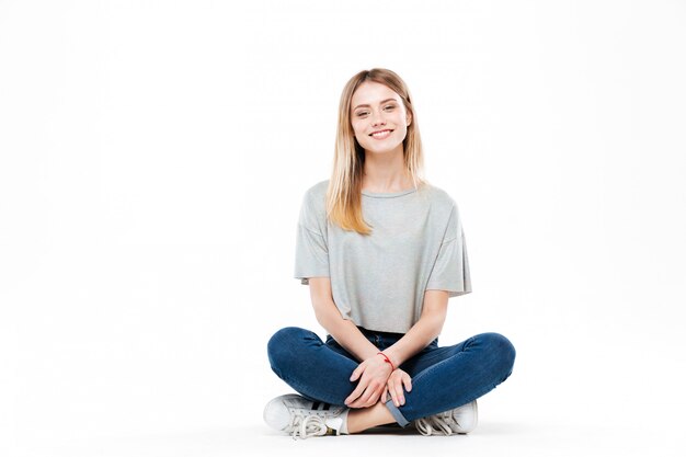 Young woman sitting cross-legged isolated