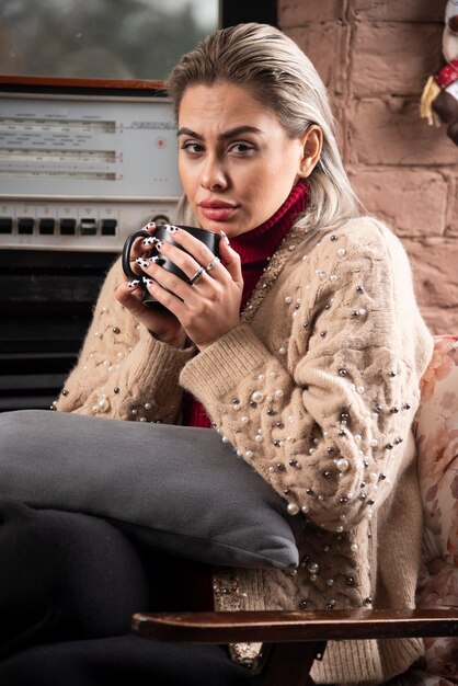 Young woman sitting and drinking a hot tea