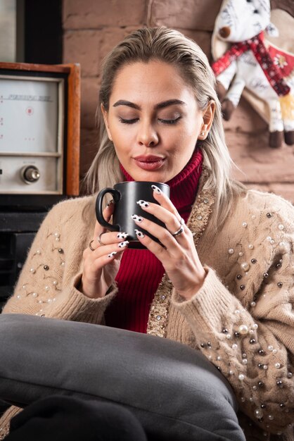 座って熱いお茶を飲む若い女性