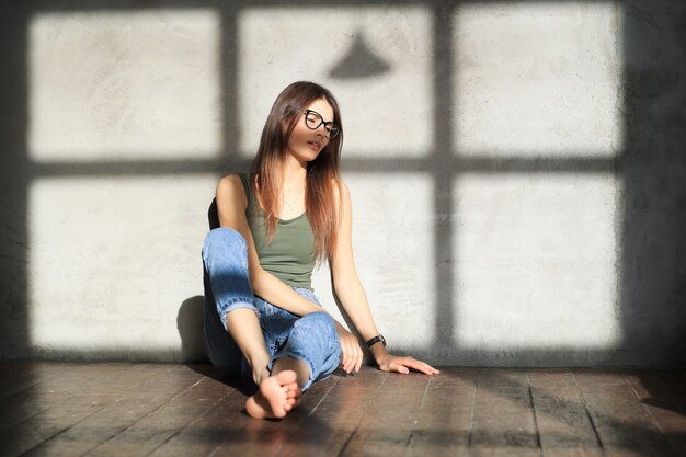 젊은 여자는 빈 방 바닥에 앉아