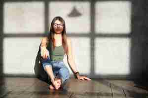 Free photo young woman sitting on the floor of an empty room