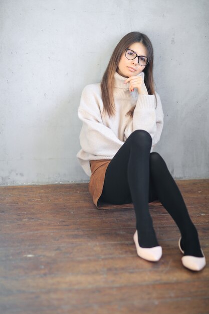 young woman sitting on the floor and posing