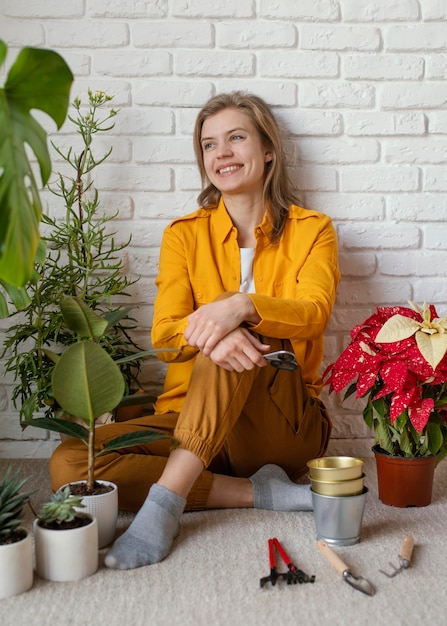 Foto gratuita giovane donna seduta sul pavimento del suo giardino di casa