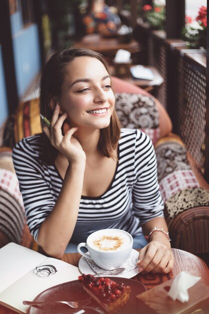 都市のカフェで屋内に座っていた若い女性