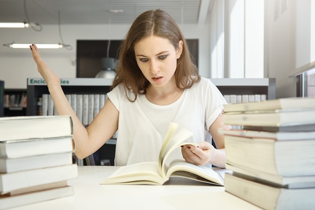 Free photo young woman sitting in library