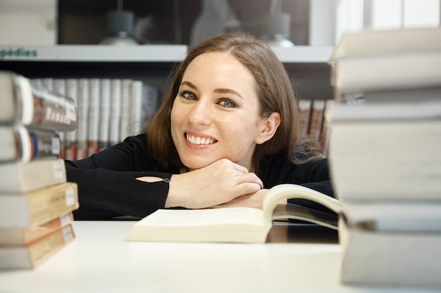 Free photo young woman sitting in library