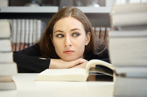 Free photo young woman sitting in library