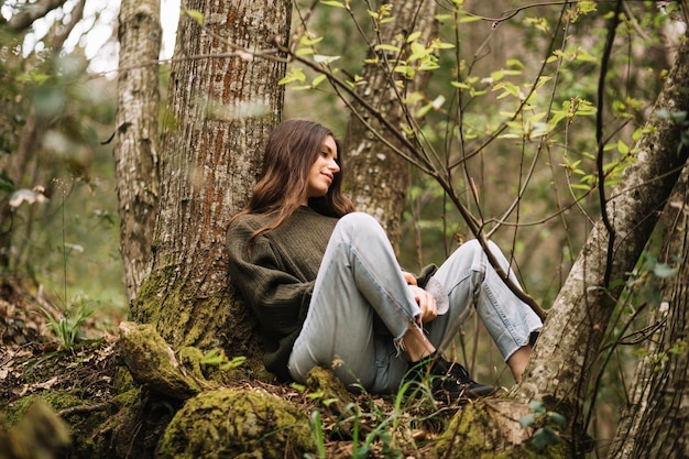 Молодая женщина, сидя на природе