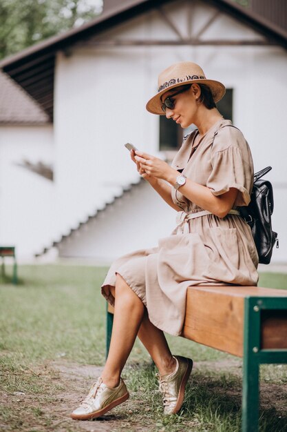 Young woman sitting park using phone