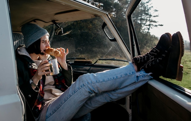 Young woman sitting in a van with her legs out