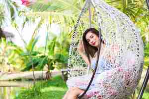 Free photo young woman sitting in white swing