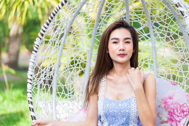 Young woman sitting in white swing