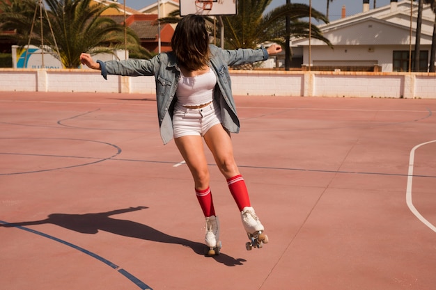 屋外コートでスケートをする若い女性