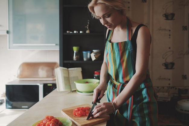 Young woman slicing tomatoes