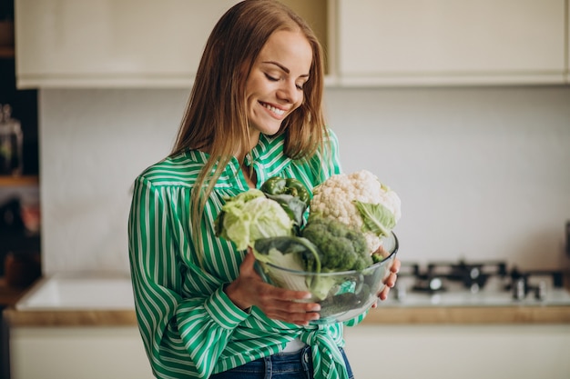 Young woman smiling and holding cauliflower