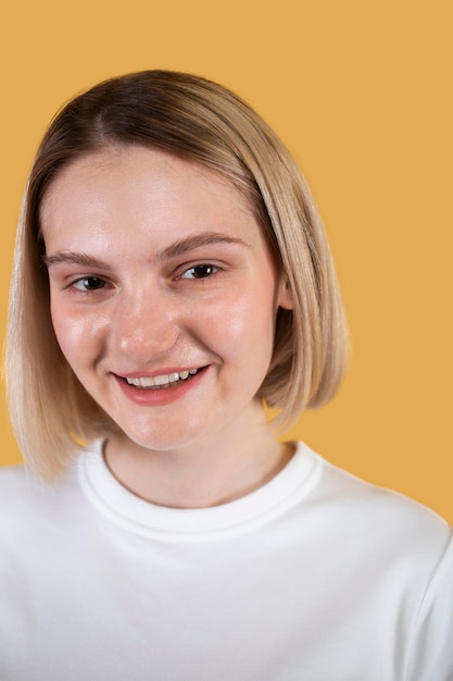 Young woman smiling isolated on yellow