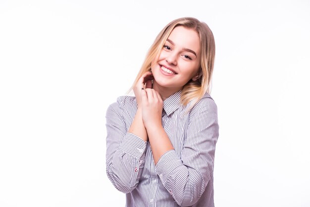 Young woman smiling touching her face isolated over white wall